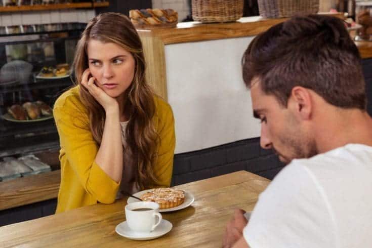 A young couple feeling distant with each other at a coffee shop