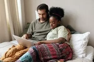 couple in bed with laptop