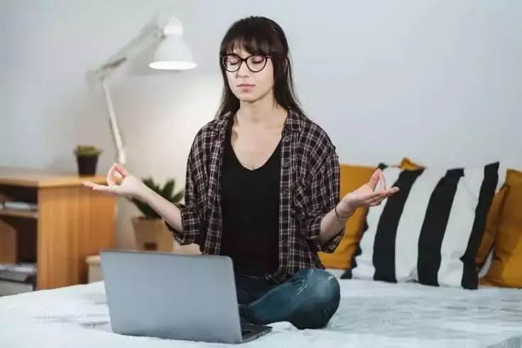 10 New Year resolutions to make college life better in 2016 7 Calm and composed woman sitting on the bed meditating.