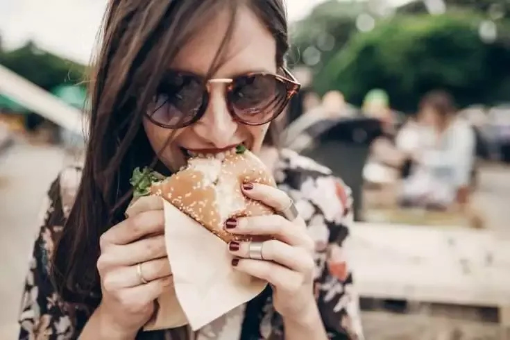 Why Food Comforts You? 7 Young woman eating a burger