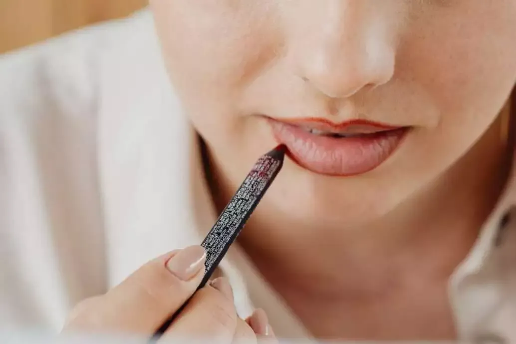 How to Do Makeup at Home (Best Guide of 2022) 19 Woman applying lip liner