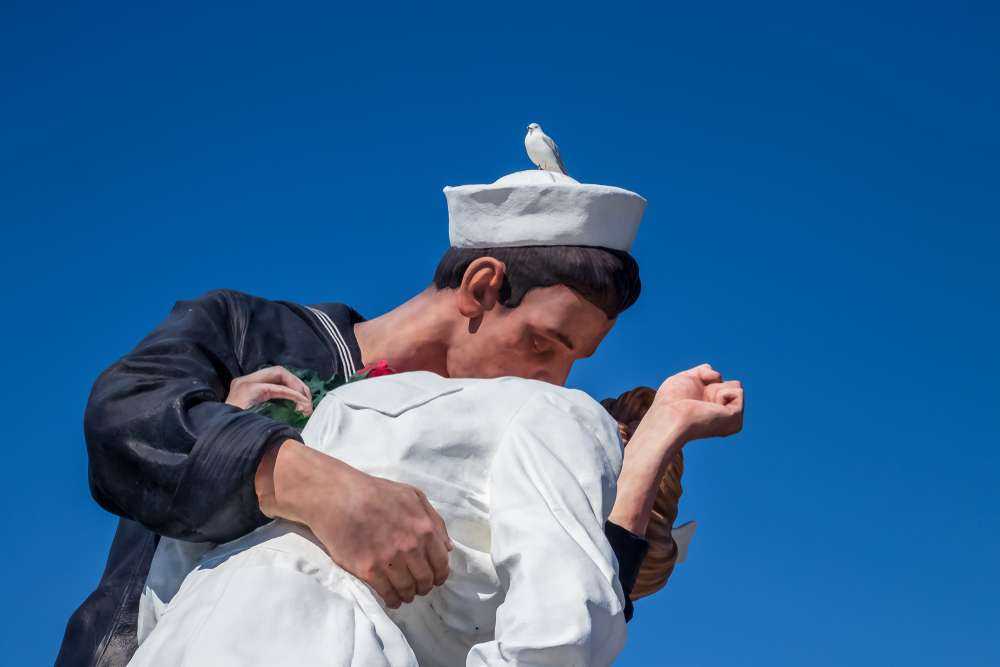 20 Historical Photographs - The Sad Past You Should Know About 9 Seagull sitting on statue depicting Alfred Eisenstaedt's picture of a U.S. Navy sailor passionately grabbing a passing woman and dipping her in an embrace
