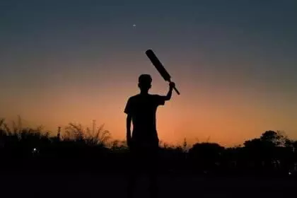 Ms Dhoni, Silhouette of a boy playing cricket in the evening with the crescent moon in the beautiful sky full of variety of colors after