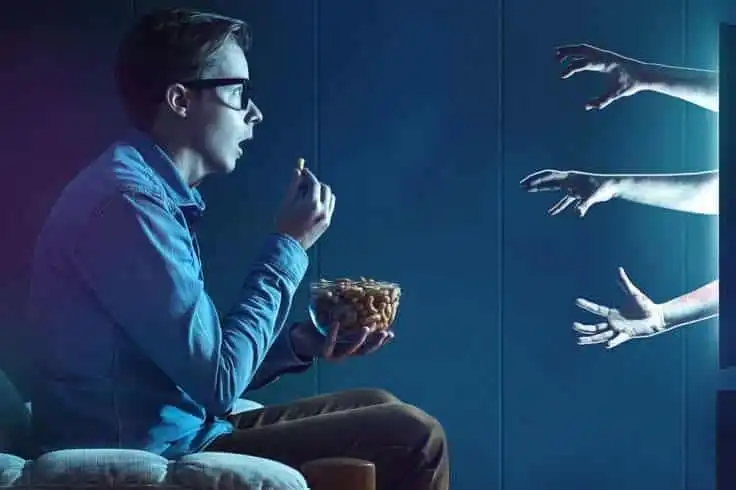 Why We Love Horror Movies 9 Yoing boy eating popcorns while watching a horror movie