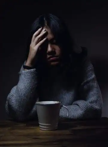 The Intriguing Science of Mind: How to Become a Psychiatrist? (Guide 2022) 9 woman with palm om forehead and coffee mug