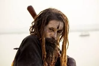  Portrait of a male hindu sadhu baba aghori pilgrim with dreadlock against ganges river