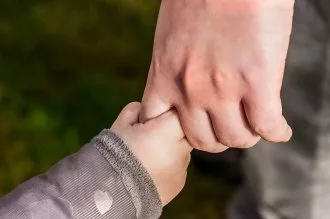 Baby holding father's hand