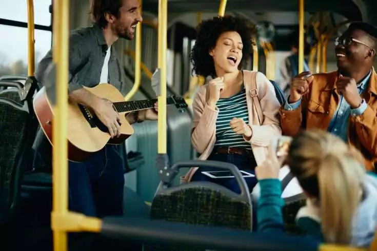 Young people singing and dancing in the bus
