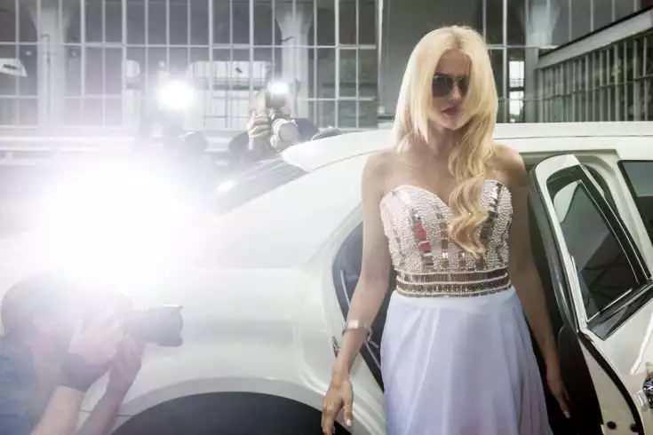 A dazzling young woman stepping out of a flashy car